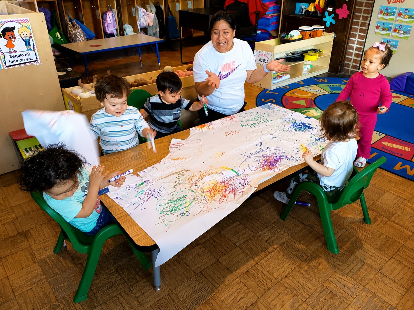 A teacher helping a Little Learners student with a hands-on art project
