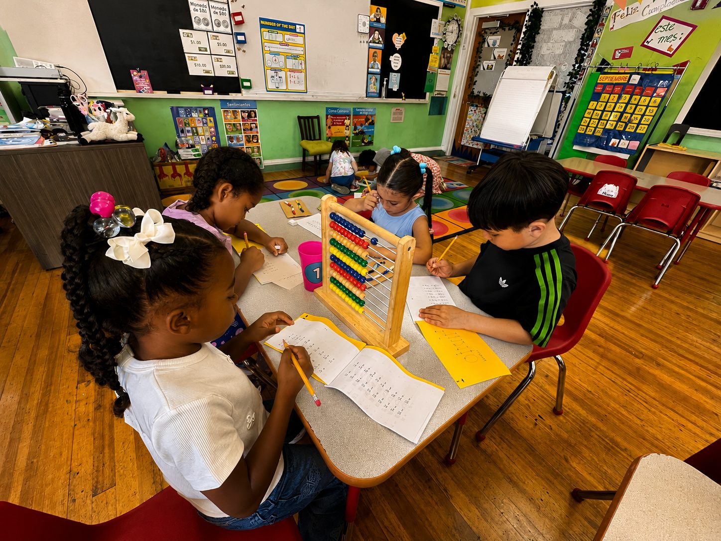 A student working through hands-on math with an abacus