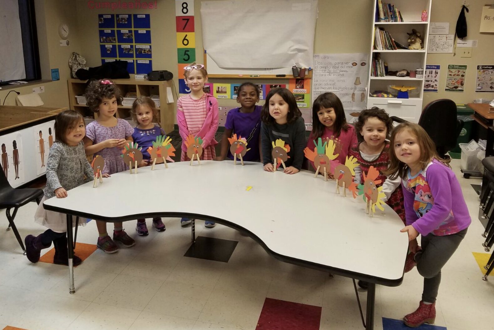 A young student showing a paper turkey craft