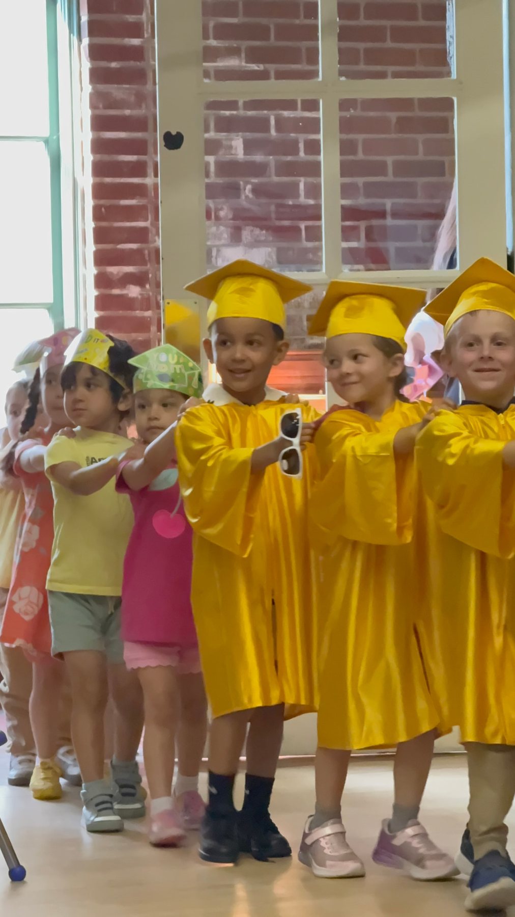 Pre-K graduates in yellow caps and gowns
