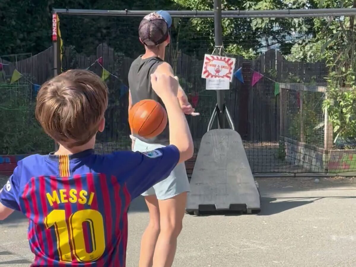 Middle school students shooting hoops on the outdoor court