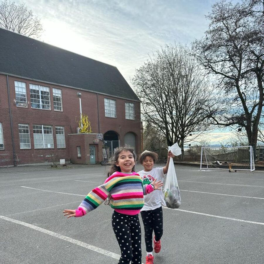 Two Amistad students jumping and laughing on the playground